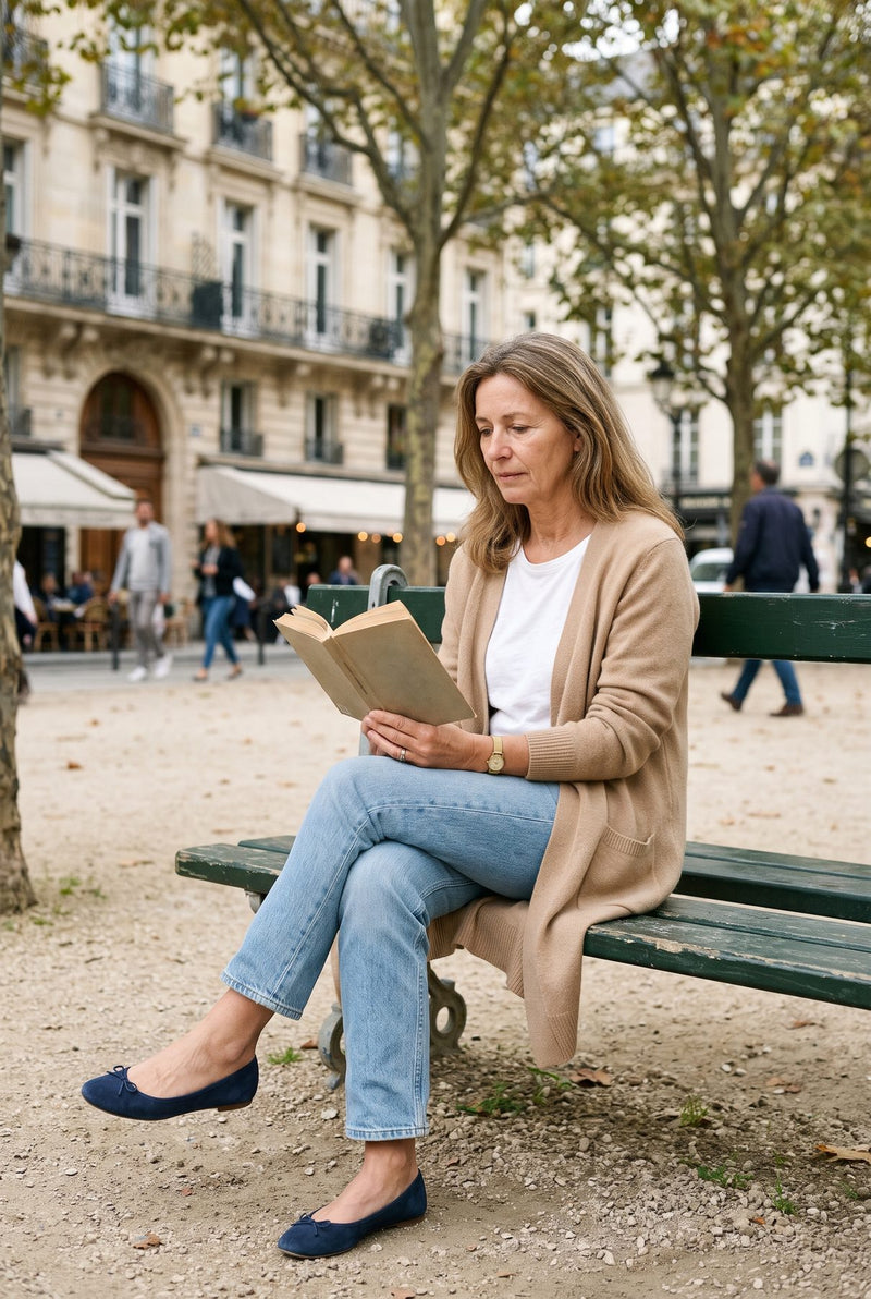 Femme en long cardigan beige lisant sur un banc